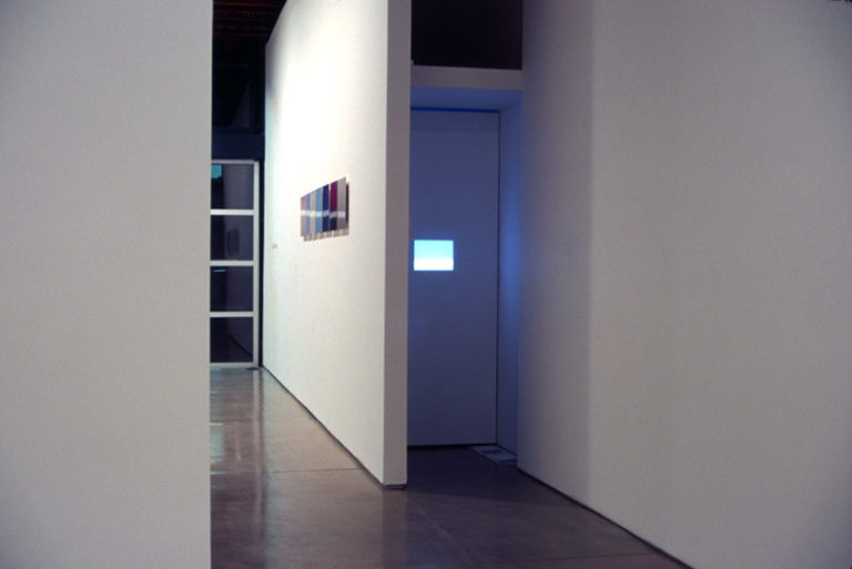 “Mia-Jfk”, video installation 8 min loop rear projected on screen (10" x 10" wall opening) 2003